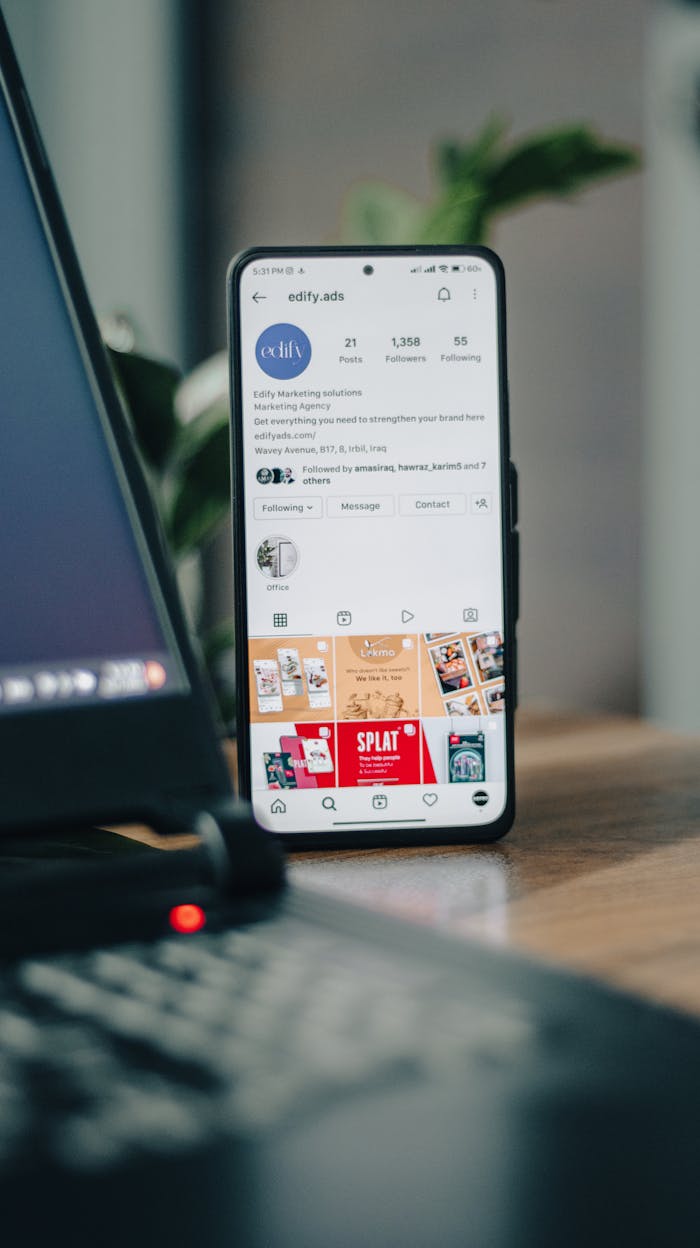 gallery-1 Vertical shot of a smartphone displaying an Instagram profile next to a laptop, representing social media engagement.