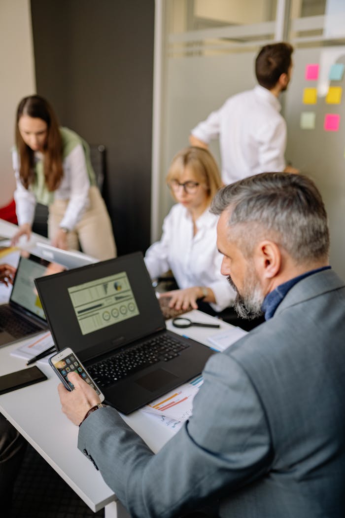 gallery-4 Corporate team working together with technology in a modern office setting, promoting collaboration and productivity.